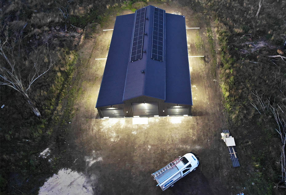 Aerial shot of shed lit up with solar powered lighting at dusk